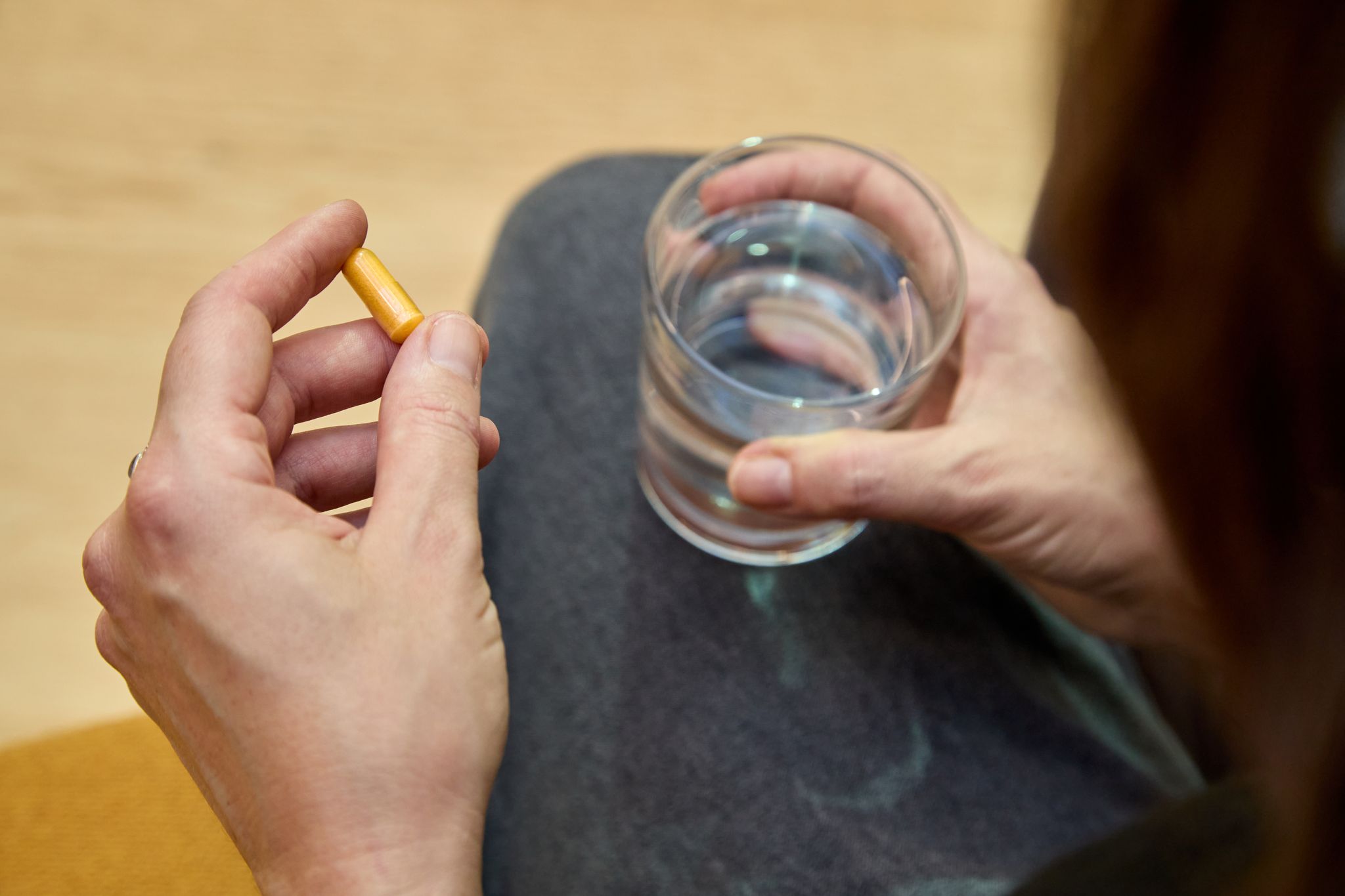 Eine Frau hält eine Kapsel mit Nahrungsergänzungsmittel