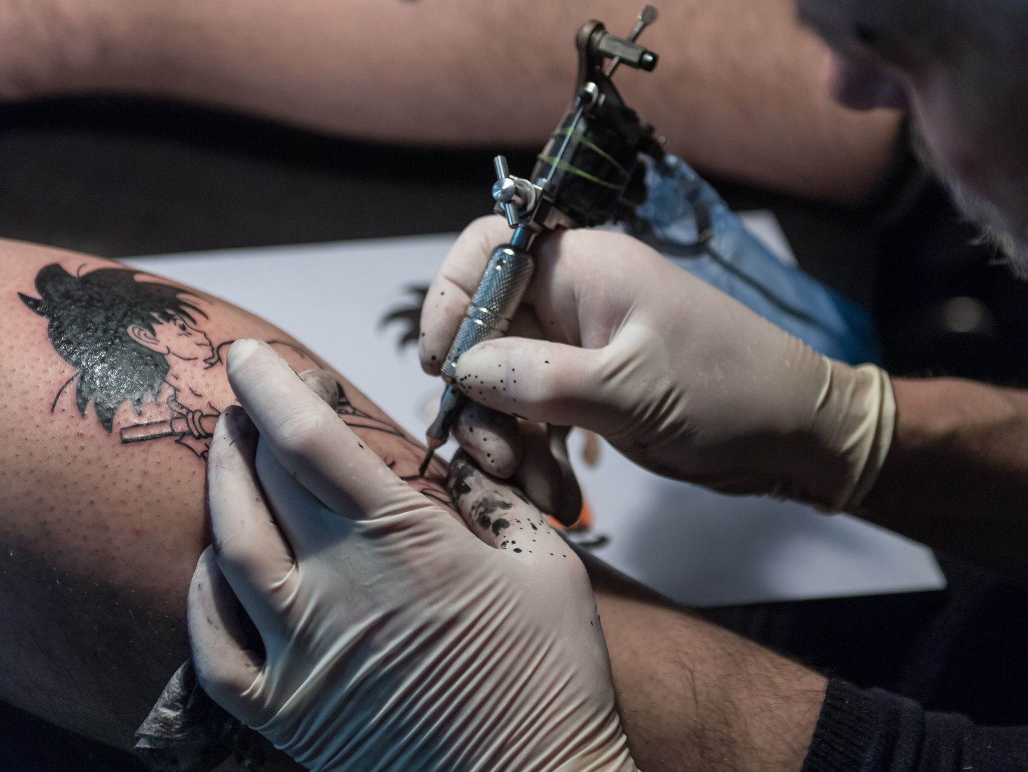 Tätowierer arbeitet an einem Tattoo