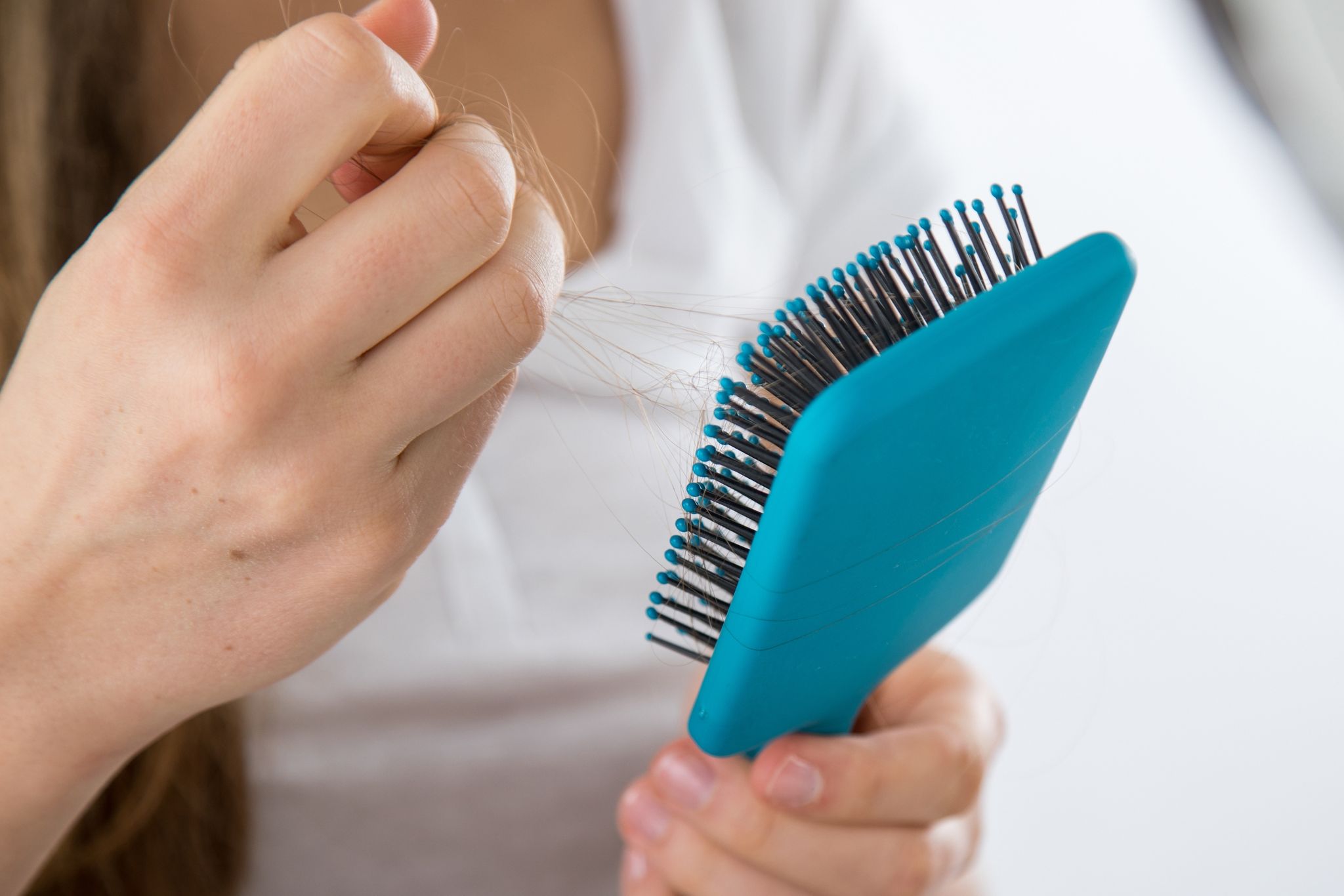 Eine Person hält eine Haarbürste in der Hand