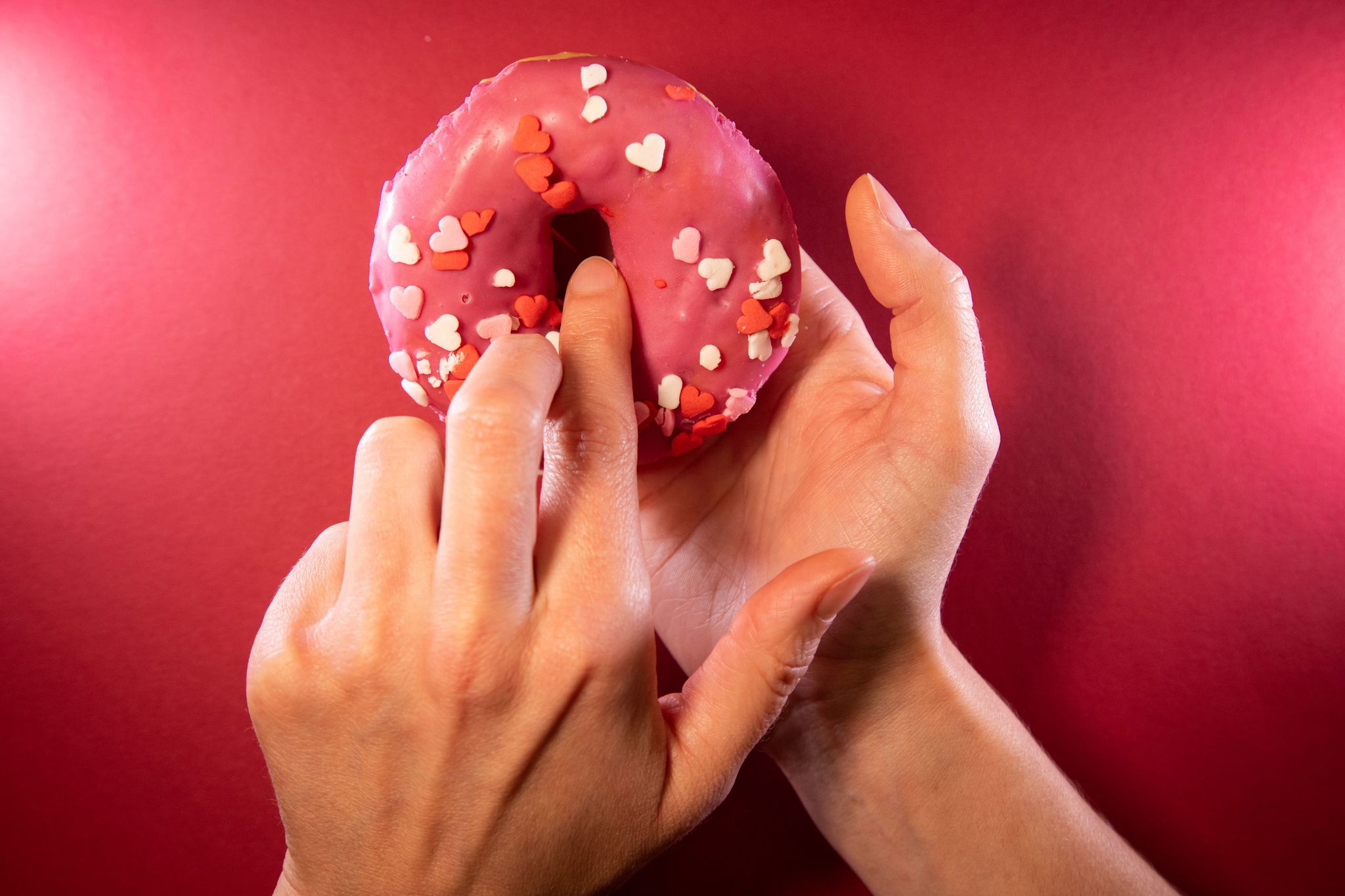 Ein Finger wird in einen Donut gesteckt