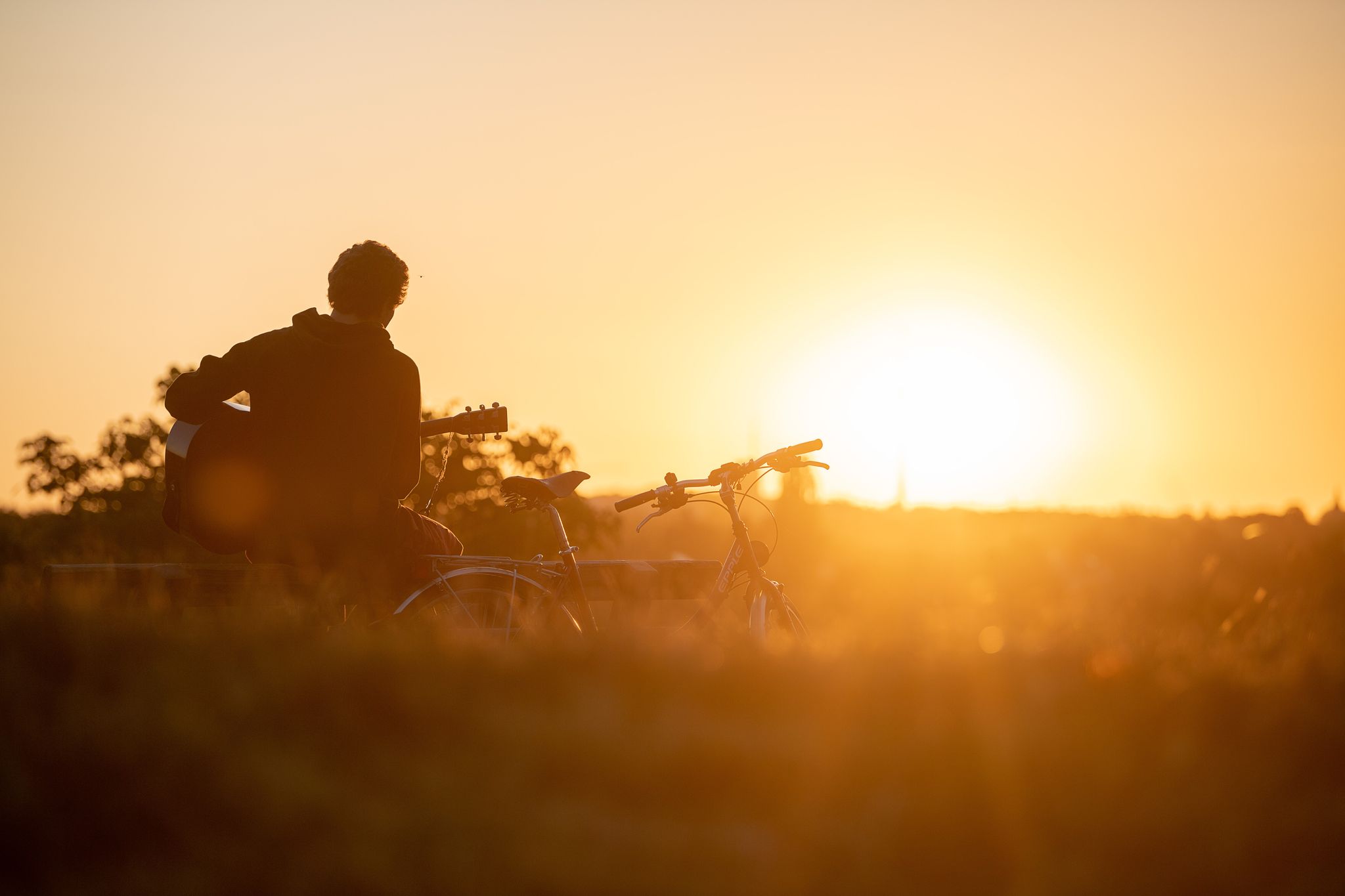 Mann spielt Gitarre im Licht der Sonne